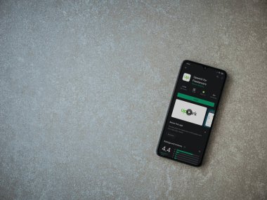 Lod, Israel - 8 Temmuz 2020: Freelancers uygulaması için seramik taş zemin üzerinde siyah bir cep telefonu sergilenen bir oyun mağazası sayfası. Üst görünüm düzlüğü kopyalama alanı ile yatıyordu.