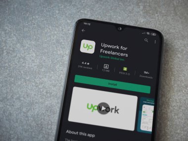 Lod, Israel - 8 Temmuz 2020: Freelancers uygulaması için seramik taş zemin üzerinde siyah bir cep telefonu sergilenen bir oyun mağazası sayfası. Üst görünüm düzlüğü kopyalama alanı ile yatıyordu.