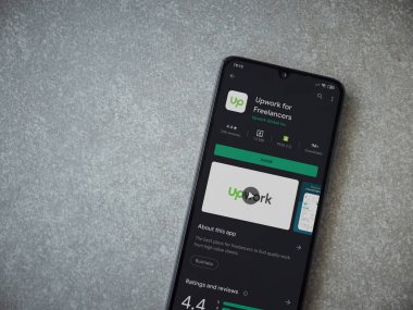 Lod, Israel - 8 Temmuz 2020: Freelancers uygulaması için seramik taş zemin üzerinde siyah bir cep telefonu sergilenen bir oyun mağazası sayfası. Üst görünüm düzlüğü kopyalama alanı ile yatıyordu.
