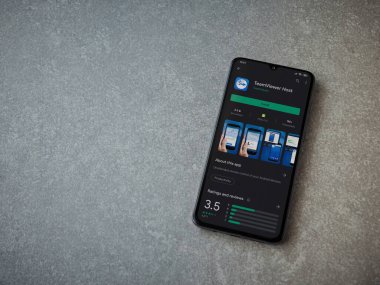 Lod, Israel - 8 Temmuz 2020: Seramik taş zemin üzerinde siyah bir mobil akıllı telefonun sergilendiği Takım İzleyici Uygulama uygulaması oyun mağazası sayfası. Üst görünüm düzlüğü kopyalama alanı ile yatıyordu.