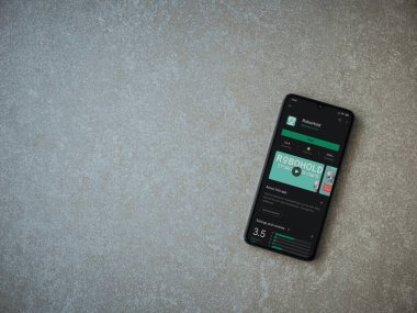 Lod, Israel - 8 Temmuz 2020: RoboHold uygulaması oyun mağazası sayfası seramik taş zemin üzerinde siyah bir cep telefonu ekranında. Üst görünüm düzlüğü kopyalama alanı ile yatıyordu.