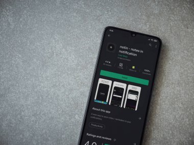 Lod, Israel - 8 Temmuz 2020: Seramik taş zemin üzerinde siyah bir cep telefonunun ekranında uygulamalı oyun mağazası sayfasında değil. Üst görünüm düzlüğü kopyalama alanı ile yatıyordu.