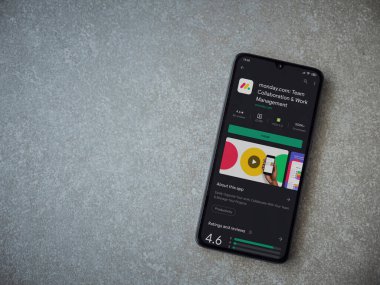 Lod, Israel - 8 Temmuz 2020: Pazartesi uygulaması oyun mağazası sayfası seramik taş zemin üzerinde siyah bir cep telefonu görüntüsü. Üst görünüm düzlüğü kopyalama alanı ile yatıyordu.