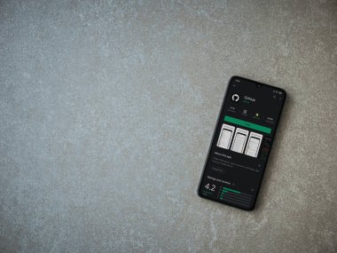 Lod, Israel - 8 Temmuz 2020: GitHub uygulaması oyun mağazası sayfası seramik taş zemin üzerinde siyah bir cep telefonu görüntüsü. Üst görünüm düzlüğü kopyalama alanı ile yatıyordu.