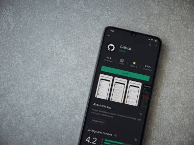 Lod, Israel - 8 Temmuz 2020: GitHub uygulaması oyun mağazası sayfası seramik taş zemin üzerinde siyah bir cep telefonu görüntüsü. Üst görünüm düzlüğü kopyalama alanı ile yatıyordu.