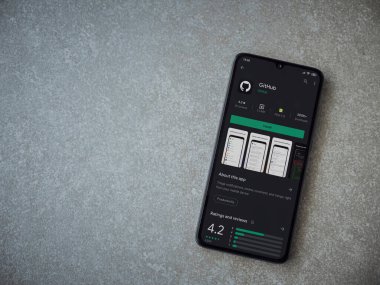 Lod, Israel - 8 Temmuz 2020: GitHub uygulaması oyun mağazası sayfası seramik taş zemin üzerinde siyah bir cep telefonu görüntüsü. Üst görünüm düzlüğü kopyalama alanı ile yatıyordu.
