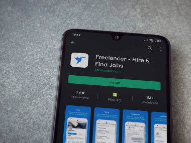 Lod, Israel - 8 Temmuz 2020: Freelancer uygulama oyun mağazası sayfası seramik taş zemin üzerinde siyah bir cep telefonu görüntüsü. Üst görünüm düzlüğü kopyalama alanı ile yatıyordu.