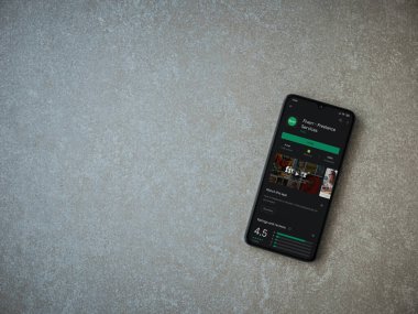 Lod, Israel - 8 Temmuz 2020: Fiverr uygulaması oyun mağazası sayfası seramik taş zemin üzerinde siyah bir cep telefonu görüntüsü. Üst görünüm düzlüğü kopyalama alanı ile yatıyordu.
