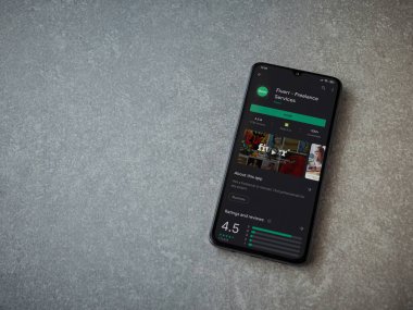 Lod, Israel - 8 Temmuz 2020: Fiverr uygulaması oyun mağazası sayfası seramik taş zemin üzerinde siyah bir cep telefonu görüntüsü. Üst görünüm düzlüğü kopyalama alanı ile yatıyordu.