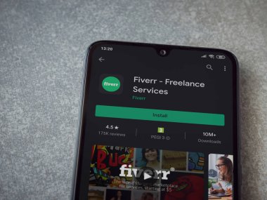 Lod, Israel - 8 Temmuz 2020: Fiverr uygulaması oyun mağazası sayfası seramik taş zemin üzerinde siyah bir cep telefonu görüntüsü. Üst görünüm düzlüğü kopyalama alanı ile yatıyordu.