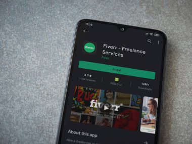 Lod, Israel - 8 Temmuz 2020: Fiverr uygulaması oyun mağazası sayfası seramik taş zemin üzerinde siyah bir cep telefonu görüntüsü. Üst görünüm düzlüğü kopyalama alanı ile yatıyordu.