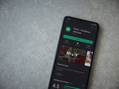 Lod, Israel - 8 Temmuz 2020: Fiverr uygulaması oyun mağazası sayfası seramik taş zemin üzerinde siyah bir cep telefonu görüntüsü. Üst görünüm düzlüğü kopyalama alanı ile yatıyordu.