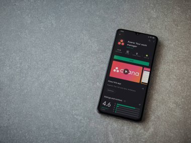 Lod, Israel - 8 Temmuz 2020: Asana uygulaması oyun mağazası sayfası seramik taş zemin üzerinde siyah bir cep telefonu görüntüsü. Üst görünüm düzlüğü kopyalama alanı ile yatıyordu.