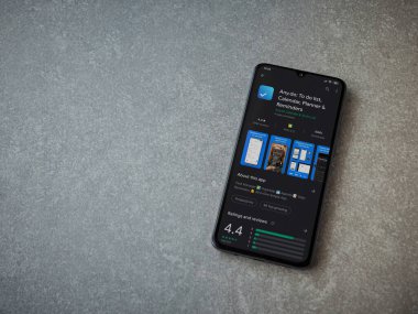 Lod, Israel - 8 Temmuz 2020: Herhangi bir uygulama oyun mağazası sayfasında seramik taş zemin üzerinde siyah bir cep telefonu görüntüsü. Üst görünüm düzlüğü kopyalama alanı ile yatıyordu.