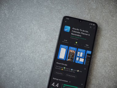 Lod, Israel - 8 Temmuz 2020: Herhangi bir uygulama oyun mağazası sayfasında seramik taş zemin üzerinde siyah bir cep telefonu görüntüsü. Üst görünüm düzlüğü kopyalama alanı ile yatıyordu.