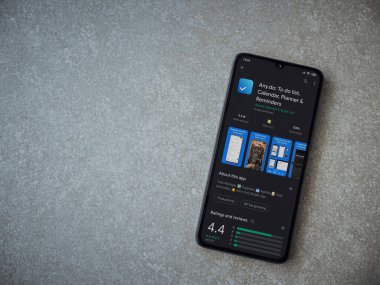 Lod, Israel - 8 Temmuz 2020: Herhangi bir uygulama oyun mağazası sayfasında seramik taş zemin üzerinde siyah bir cep telefonu görüntüsü. Üst görünüm düzlüğü kopyalama alanı ile yatıyordu.