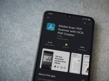 Lod, Israel - 8 Temmuz 2020: Seramik taş zemin üzerinde siyah bir cep telefonu ekranında Adobe Scan uygulaması oyun mağazası sayfası. Üst görünüm düzlüğü kopyalama alanı ile yatıyordu.