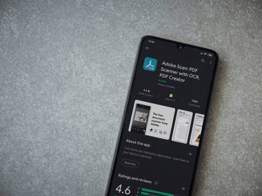 Lod, Israel - 8 Temmuz 2020: Seramik taş zemin üzerinde siyah bir cep telefonu ekranında Adobe Scan uygulaması oyun mağazası sayfası. Üst görünüm düzlüğü kopyalama alanı ile yatıyordu.