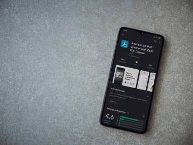 Lod, Israel - 8 Temmuz 2020: Seramik taş zemin üzerinde siyah bir cep telefonu ekranında Adobe Scan uygulaması oyun mağazası sayfası. Üst görünüm düzlüğü kopyalama alanı ile yatıyordu.