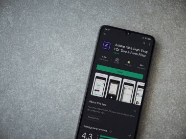 Lod, Israel - 8 Temmuz 2020: Seramik taş zemin üzerinde siyah bir cep telefonunun gösterildiği Adobe Doldur ve İmzala uygulaması oyun mağazası sayfası. Üst görünüm düzlüğü kopyalama alanı ile yatıyordu.