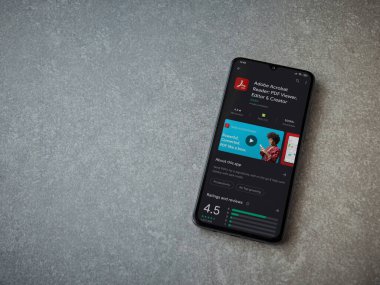 Lod, Israel - 8 Temmuz 2020: Adobe Acrobat Reader uygulama oyun mağazası sayfası seramik taş zemin üzerinde siyah bir cep telefonu görüntüsü. Üst görünüm düzlüğü kopyalama alanı ile yatıyordu.