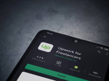 Lod, Israel - 8 Temmuz 2020: Freelancers uygulaması için geliştirme oyun mağazası sayfası koyu mermer taşlı arka planda siyah bir cep telefonu görüntüsü. Üst görünüm düzlüğü kopyalama alanı ile yatıyordu.