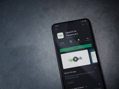 Lod, Israel - 8 Temmuz 2020: Freelancers uygulaması için geliştirme oyun mağazası sayfası koyu mermer taşlı arka planda siyah bir cep telefonu görüntüsü. Üst görünüm düzlüğü kopyalama alanı ile yatıyordu.
