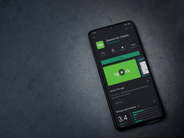 Lod, Israel - 8 Temmuz 2020: Koyu mermer taştan arka planda siyah bir cep telefonunun ekranında müşteriler için uygulama oyun mağazası sayfası güncellemesi. Üst görünüm düzlüğü kopyalama alanı ile yatıyordu.
