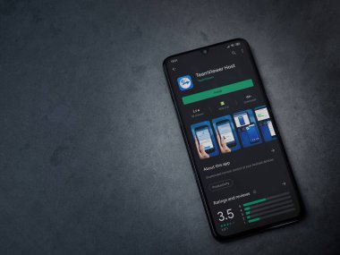 Lod, Israel - 8 Temmuz 2020: Takım İzleyici Uygulama Oyun Mağazası sayfası koyu mermer taştan arka planda siyah bir cep telefonu görüntüsü. Üst görünüm düzlüğü kopyalama alanı ile yatıyordu.