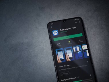 Lod, Israel - 8 Temmuz 2020: Takım İzleyici Uygulama Oyun Mağazası sayfası koyu mermer taştan arka planda siyah bir cep telefonu görüntüsü. Üst görünüm düzlüğü kopyalama alanı ile yatıyordu.