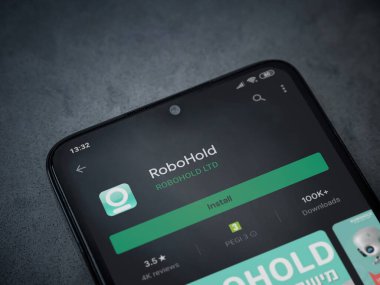 Lod, Israel - 8 Temmuz 2020: RoboHold uygulaması oyun mağazası sayfası koyu mermer taştan arka planda siyah bir cep telefonu ekranında. Üst görünüm düzlüğü kopyalama alanı ile yatıyordu.