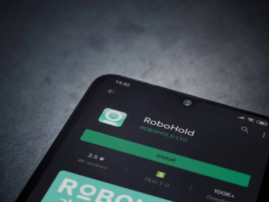 Lod, Israel - 8 Temmuz 2020: RoboHold uygulaması oyun mağazası sayfası koyu mermer taştan arka planda siyah bir cep telefonu ekranında. Üst görünüm düzlüğü kopyalama alanı ile yatıyordu.