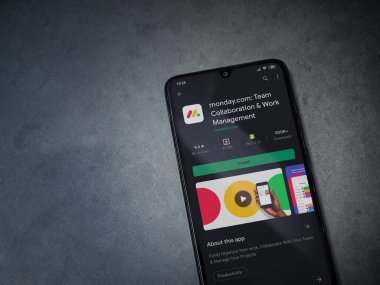 Lod, Israel - 8 Temmuz 2020: Pazartesi uygulaması oyun mağazası sayfası koyu mermer taşlı arka planda siyah bir cep telefonunun ekranında. Üst görünüm düzlüğü kopyalama alanı ile yatıyordu.