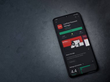 Lod, Israel - 8 Temmuz 2020: LastPass Şifre Yöneticisi uygulama oyun mağazası sayfası koyu mermer taştan arka planda siyah bir cep telefonu sergilenmektedir. Üst görünüm düzlüğü kopyalama alanı ile yatıyordu.