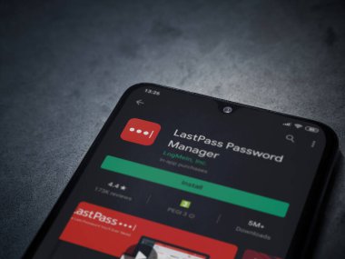 Lod, Israel - 8 Temmuz 2020: LastPass Şifre Yöneticisi uygulama oyun mağazası sayfası koyu mermer taştan arka planda siyah bir cep telefonu sergilenmektedir. Üst görünüm düzlüğü kopyalama alanı ile yatıyordu.