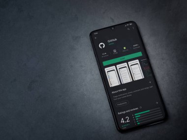 Lod, Israel - 8 Temmuz 2020: GitHub uygulama oyun mağazası sayfası koyu mermer taştan arka planda siyah bir cep telefonu ekranında. Üst görünüm düzlüğü kopyalama alanı ile yatıyordu.
