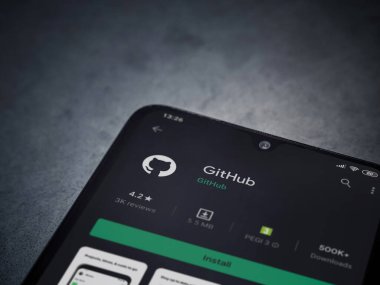 Lod, Israel - 8 Temmuz 2020: GitHub uygulama oyun mağazası sayfası koyu mermer taştan arka planda siyah bir cep telefonu ekranında. Üst görünüm düzlüğü kopyalama alanı ile yatıyordu.