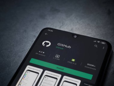 Lod, Israel - 8 Temmuz 2020: GitHub uygulama oyun mağazası sayfası koyu mermer taştan arka planda siyah bir cep telefonu ekranında. Üst görünüm düzlüğü kopyalama alanı ile yatıyordu.