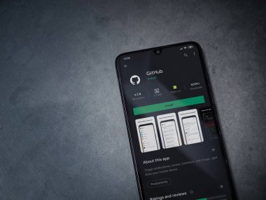 Lod, Israel - 8 Temmuz 2020: GitHub uygulama oyun mağazası sayfası koyu mermer taştan arka planda siyah bir cep telefonu ekranında. Üst görünüm düzlüğü kopyalama alanı ile yatıyordu.