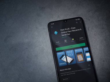 Lod, Israel - 8 Temmuz 2020: Faks Plus uygulama oyun mağazası sayfası koyu mermer taştan arka planda siyah bir cep telefonunun ekranında. Üst görünüm düzlüğü kopyalama alanı ile yatıyordu.
