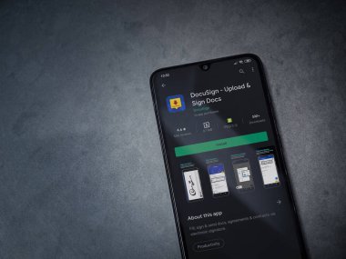 Lod, Israel - 8 Temmuz 2020: Docusign uygulaması oyun mağazası sayfası koyu mermer taştan arka planda siyah bir cep telefonunun ekranında. Üst görünüm düzlüğü kopyalama alanı ile yatıyordu.