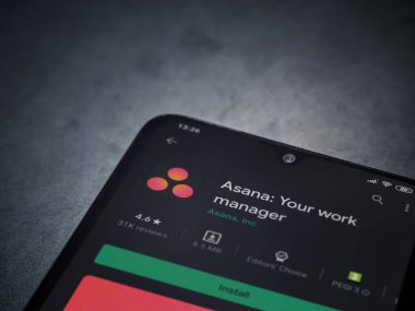 Lod, Israel - 8 Temmuz 2020: Asana uygulaması oyun mağazası sayfası koyu mermer taştan arka planda siyah bir cep telefonu ekranında. Üst görünüm düzlüğü kopyalama alanı ile yatıyordu.