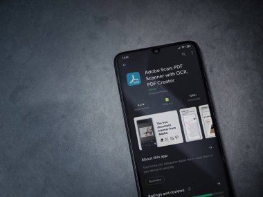Lod, Israel - 8 Temmuz 2020: Adobe Scan uygulama oyun mağazası sayfası koyu mermer taşlı arka planda siyah bir cep telefonu görüntüsü. Üst görünüm düzlüğü kopyalama alanı ile yatıyordu.