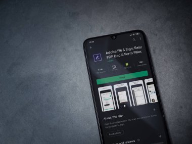 Lod, Israel - 8 Temmuz 2020: Adobe Doldur & İmzala uygulaması oyun mağazası sayfası koyu mermer taştan arka planda siyah bir cep telefonu görüntüsü. Üst görünüm düzlüğü kopyalama alanı ile yatıyordu.