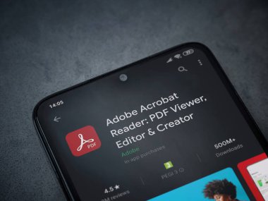 Lod, Israel - 8 Temmuz 2020: Adobe Acrobat Reader uygulama oyun mağazası sayfası koyu mermer taştan arka planda siyah bir cep telefonu görüntüsü. Üst görünüm düzlüğü kopyalama alanı ile yatıyordu.