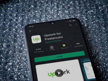 Lod, Israel - 8 Temmuz 2020: Freelancers uygulaması için metalik arka planda siyah bir cep telefonunun yer aldığı oyun mağazası sayfası güncellemesi. Üst görünüm yatağını kapat.
