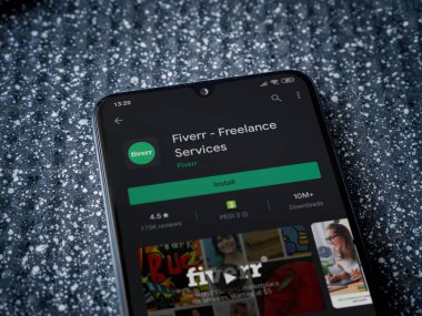 Lod, Israel - 8 Temmuz 2020: Fiverr uygulama oyun mağazası sayfası metalik arka planda siyah bir cep telefonunun ekranında. Üst görünüm yatağını kapat.