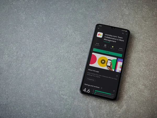 Lod, Israel - 8 Temmuz 2020: Pazartesi uygulaması oyun mağazası sayfası seramik taş zemin üzerinde siyah bir cep telefonu görüntüsü. Üst görünüm düzlüğü kopyalama alanı ile yatıyordu.