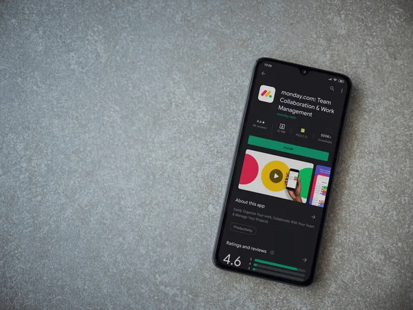 Lod, Israel - 8 Temmuz 2020: Pazartesi uygulaması oyun mağazası sayfası seramik taş zemin üzerinde siyah bir cep telefonu görüntüsü. Üst görünüm düzlüğü kopyalama alanı ile yatıyordu.