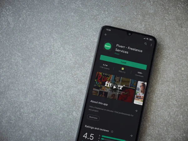 Lod, Israel - 8 Temmuz 2020: Fiverr uygulaması oyun mağazası sayfası seramik taş zemin üzerinde siyah bir cep telefonu görüntüsü. Üst görünüm düzlüğü kopyalama alanı ile yatıyordu.